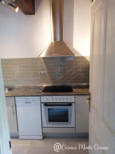 a kitchen with a stove top oven next to a door at Casa con encanto en La Hayuela, situada a 5 min de Comillas in Udias