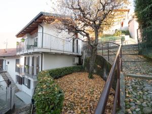 a house with a tree in front of it at Bellano Holidays - Casa Ortensia in Bellano