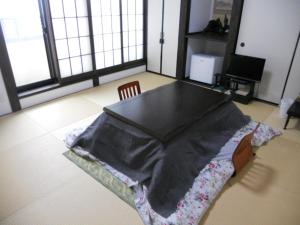 uma mesa com um cobertor numa cadeira num quarto em Guest House Koundo em Nikko