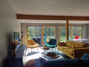 sala de estar con sofá, sillas y mesa en Villa avec Piscine Les Planches à Saint Valery Somme en Saint-Valery-sur-Somme