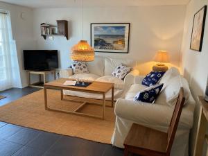 - un salon avec un canapé blanc et une table dans l'établissement Lunkaberg Bed & Breakfast, à Simrishamn