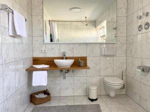 a bathroom with a sink and a toilet and a mirror at Best Butler Boho Boutique City Apartment Netflix in Füssen +24 photos