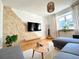 un soggiorno con divano e parete in pietra di Best Butler Boho Boutique City Apartment Netflix a Füssen
