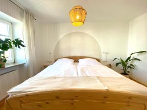 a bedroom with a large white bed with a chandelier at Best Butler Boho Boutique City Apartment Netflix in Füssen