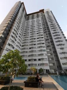 two people sitting in front of a large apartment building at Avida Davao Condos, downtown CM Recto Avenue, Davao City in Davao City