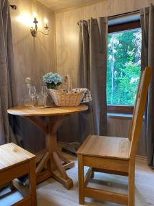 a table with a basket and a chair and a window at Mountain cottage in Parád