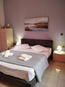 a bedroom with two beds and a painting on the wall at Anna's Home in Ermoupoli