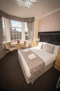 ein Schlafzimmer mit einem großen Bett und einem großen Fenster in der Unterkunft Clifton Park Hotel - Exclusive to Adults in Lytham St Annes