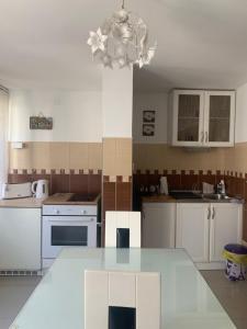a kitchen with white cabinets and a table in it at Apartment A&D in Pančevo