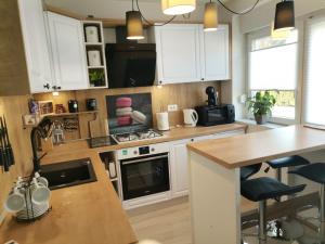 a kitchen with white cabinets and a counter top at Apartman Anamaria in Gospić +9 photos