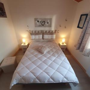 ein Schlafzimmer mit einem großen weißen Bett mit zwei Lampen in der Unterkunft La commanderie in La Tranche-sur-Mer