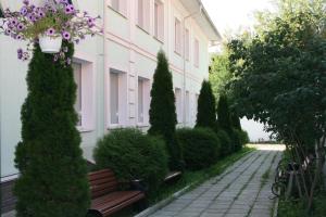 un banco frente a un edificio con flores en Tsentralnaya Hotel, en Sergiyev Posad