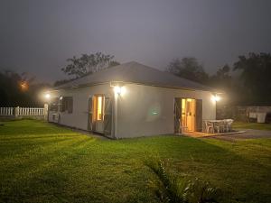 圣若瑟Gîte des Dodos的夜晚在院子里有灯的白色房子