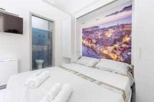 a white bedroom with a view of the city at La casa del postino in Procida