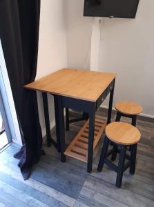 a wooden table and two stools in a room at Studio type T1 avec parking et cave à 600 m de la plage in Fréjus +7 photos