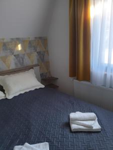 1 dormitorio con 1 cama con 2 toallas en Šumske priče Divčibare, en Divčibare