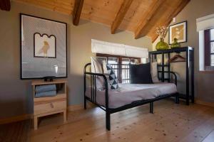 a bedroom with a black bed and a wooden floor at Víkendovka Korce - Apartmán Mácha in Dubá