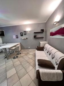 a room with a couch and a desk and a table at Appartamento Emerald in Sirmione