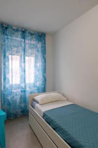 a bedroom with a bed and blue curtains at Suite LA CONCHIGLIA località Caccia e Riserva in Santa Marinella