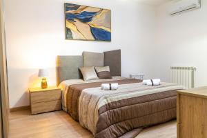 sypialnia z łóżkiem i obrazem na ścianie w obiekcie Diana Holiday Home w mieście Agrigento