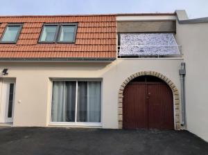 une maison avec un toit rouge et un garage dans l'établissement T2 en duplex & terrasse, à Saint-Priest