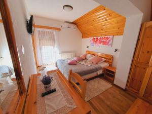 Un dormitorio con una cama con almohadas rosas. en Plitvice Green Valley en Plitvička Jezera
