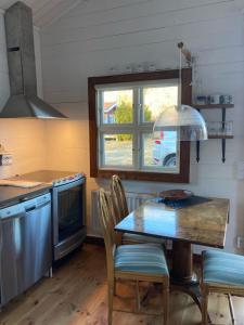 cocina con mesa, sillas y ventana en Stor stugan, en Blankaholm