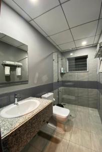 a bathroom with a sink and a toilet and a mirror at VAMA Retreats in Bangalore