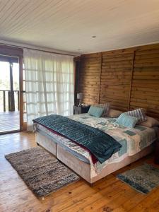 a bedroom with a large bed with a wooden wall at Kosy place in KwaMazambane