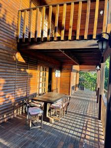 eine Holzterrasse mit einem Holztisch und Stühlen in der Unterkunft Kosy place in KwaMazambane