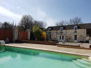 uma piscina vazia em frente a uma casa em La Charrue gite complex em Monsec