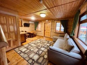 - un salon dans une cabane en rondins avec un canapé dans l'établissement Sky Land Camping & Resort, à Chişinău