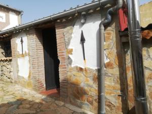 um edifício com uma porta vermelha e uma janela em La casita del herrador em El Burgo de Osma