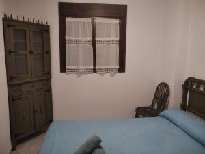 um quarto com uma cama, uma cómoda e uma janela em La casita del herrador em El Burgo de Osma