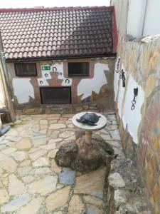 um pátio de pedra com uma mesa em frente a um edifício em La casita del herrador em El Burgo de Osma
