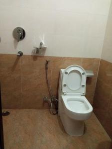 a bathroom with a toilet with a shower at Hotel Kanthak in Lumbini