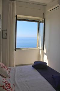 een slaapkamer met een bed en een groot raam bij Casa Colombo in Vietri