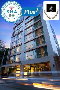 Amora NeoLuxe Suites Hotel في بانكوك: مبنى مع علامة على أنه يقرأ شا زائد