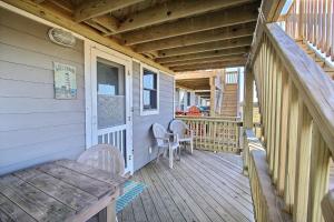 a wooden porch with a table and chairs on it at 2 Cabana By The Sea Condo in Hatteras