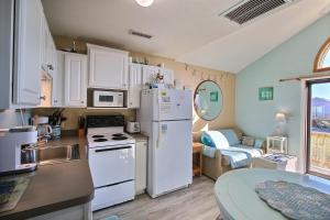 a kitchen with a white refrigerator and a table at 2 Cabana By The Sea Condo in Hatteras