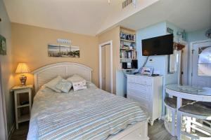 a bedroom with a bed and a desk with a television at 2 Cabana By The Sea Condo in Hatteras