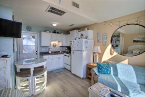 a small kitchen with a white refrigerator and a table at 2 Cabana By The Sea Condo in Hatteras