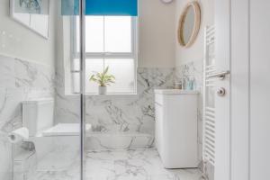 a white bathroom with a shower and a toilet at Ellinbrook Guest House in Hunstanton