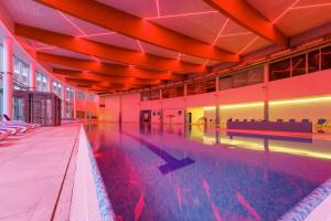 an empty swimming pool in a large building at Hotel Senator in Dźwirzyno