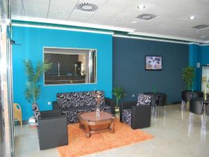 een lobby met blauwe muren en een tafel en stoelen bij Hotel Almoradi in Almoradí