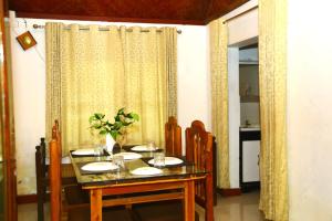 a dining room with a table and chairs and a window at VALENTINE'S RICE BOWL HOME STAY in Alleppey