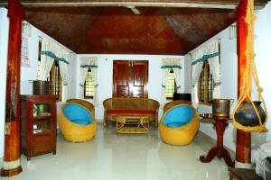 a living room with yellow chairs and a couch at VALENTINE'S RICE BOWL HOME STAY in Alleppey