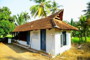 a small house with a roof with palm trees at VALENTINE'S RICE BOWL HOME STAY in Alleppey
