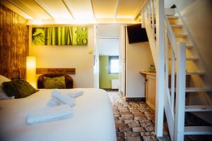 a bedroom with a white bed and a staircase at Hotel Le Dauphin in Honfleur