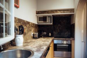 a kitchen with a sink and a microwave at Hotel Le Dauphin in Honfleur